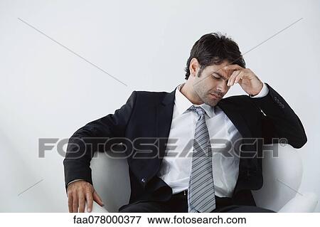 Stock Photo - Businessman holding head in disappointment. Fotosearch