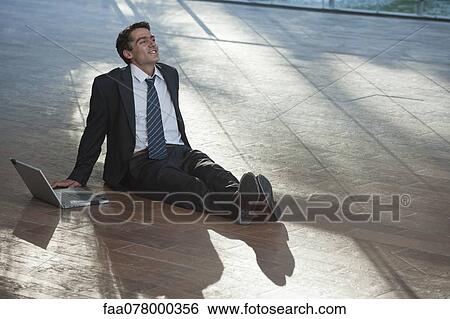 Stock Photograph - Businessman relaxing on deck with laptop computer. Fotosearch