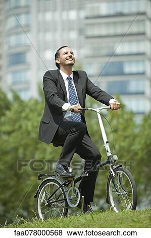 Stock Photo - Businessman riding bicycle. Fotosearch