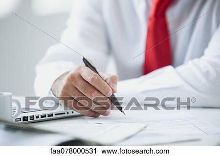 Stock Image - Businessman working at desk. Fotosearch