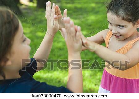 Stock Image - Children playing pattycake. Fotosearch
