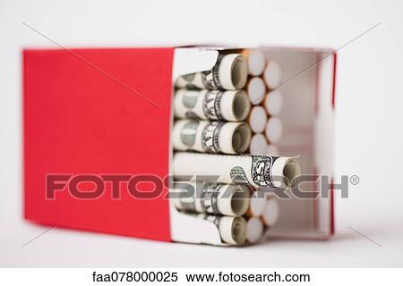Stock Photography - Cigarette pack containing rolled dollars. Fotosearch