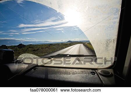 Stock Image - Country road viewed through car windshield. Fotosearch