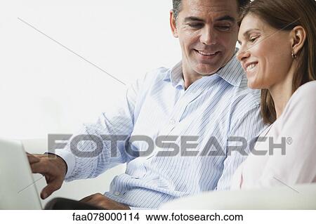Couple looking at laptop computer together View Large Photo Image Picture - Couple looking at laptop computer together. Fotosearch