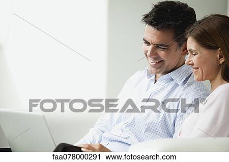 Couple looking at laptop computer together View Large Photo Image Stock Image - Couple looking at laptop computer together. Fotosearch