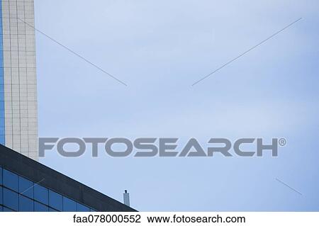 Stock Image - Cropped buildings against blue sky. Fotosearch