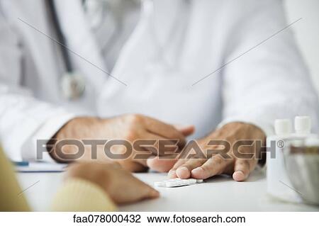 Stock Image - Doctor providing patient with prescription drugs. Fotosearch