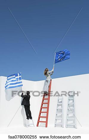 Stock Photography - Executives climbing ladders, holding European Union flag and Greek flag to symbolize economic crisis. Fotosearch