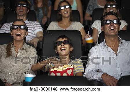 Stock Photo - Family watching 3-D movie in theater. Fotosearch