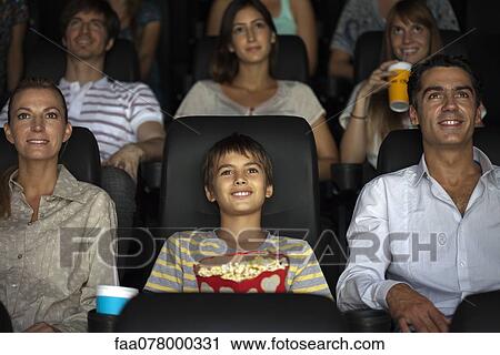 Stock Image - Family watching movie in theater. Fotosearch