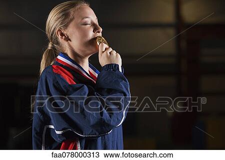 Female athlete kissing gold medal View Large Photo Image Stock Image - Female athlete kissing gold medal. Fotosearch