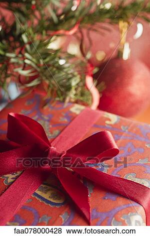 Stock Photo - Festively wrapped Christmas gift, close-up. Fotosearch