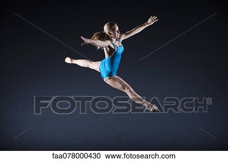 Stock Image - Gymnast jumping in air. Fotosearch