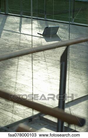 Stock Image - Laptop computer on hardwood floor. Fotosearch