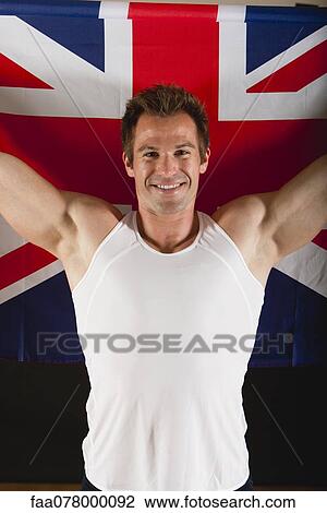 Stock Image - Male athlete in front of British flag, portrait. Fotosearch