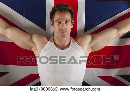 Stock Image - Male athlete in front of British flag, portrait. Fotosearch