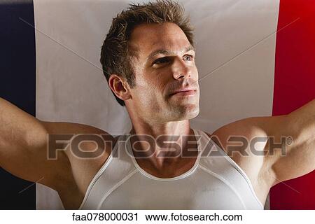 Stock Image - Male athlete in front of French flag. Fotosearch