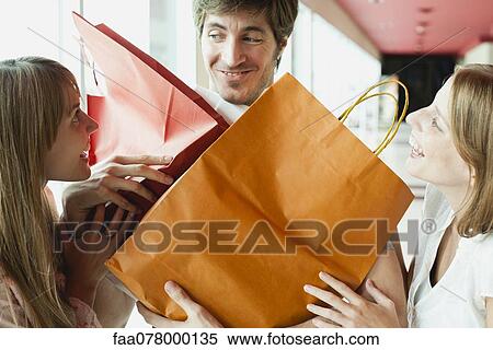 Stock Photography - Man holding shopping bags for friends. Fotosearch