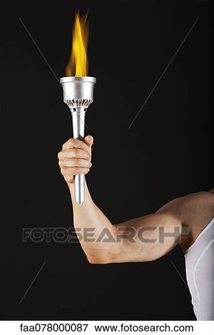 Stock Photo - Man holding torch, cropped. Fotosearch