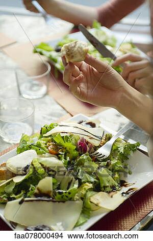 Picture - People enjoying healthy salad, cropped. Fotosearch