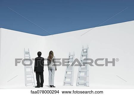 Picture - Professionals contemplating ladders, rear view. Fotosearch