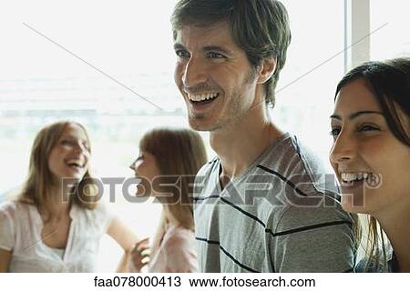 Smiling couple, women in background View Large Photo Image Stock Image - Smiling couple, women in background. Fotosearch