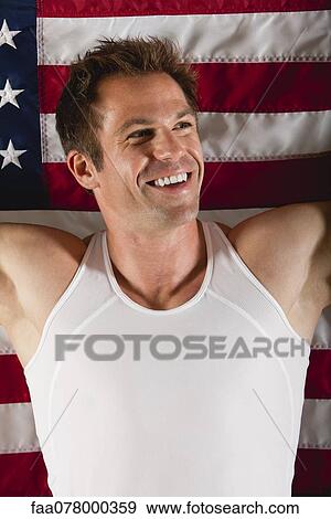 Stock Photo - Smiling male athlete in front of American flag. Fotosearch