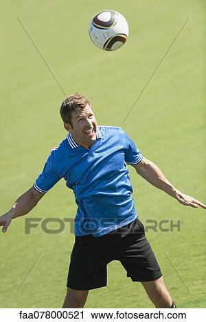 Stock Image - Soccer player heading the ball. Fotosearch