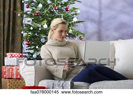 Stock Photography - Woman shopping online for Christmas gifts. Fotosearch