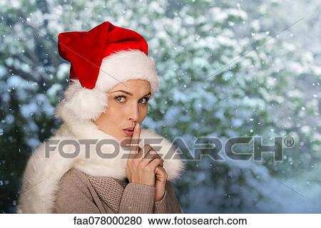 Woman wearing Santa hat, finger on lips, portrait View Large Photo Image Stock Image - Woman wearing Santa hat, finger on lips, portrait. Fotosearch