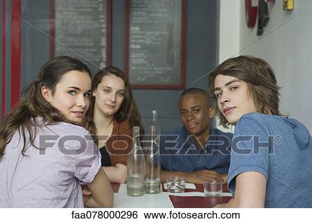 Stock Photograph - Young adult friends hanging out in cafe. Fotosearch