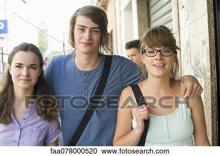 Stock Image - Young adult friends smiling at camera. Fotosearch
