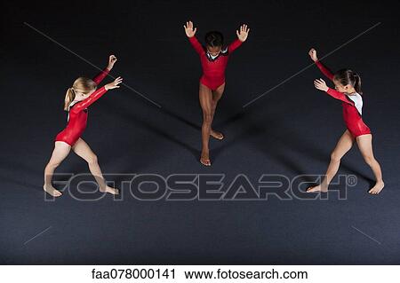 Stock Image - Young girl gymnasts preparing to perform handstands. Fotosearch
