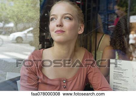 Young woman at sidewalk cafe, looking up and smiling View Large Photo Image Stock Photo - Young woman at sidewalk cafe, looking up and smiling. Fotosearch