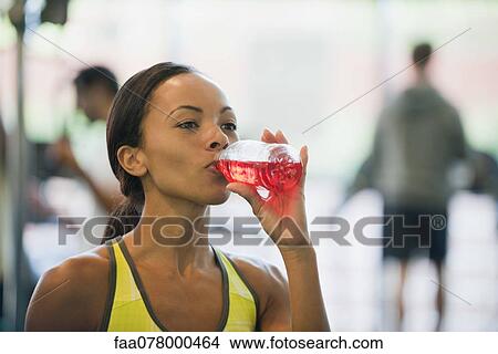 Young woman drinking sports drink View Large Photo Image Picture - Young woman drinking sports drink. Fotosearch