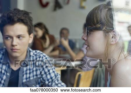 Stock Image - Young woman hanging out with friends in cafe. Fotosearch