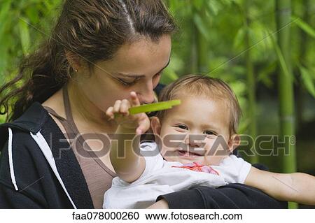 Stock Image - Young woman holding baby girl. Fotosearch