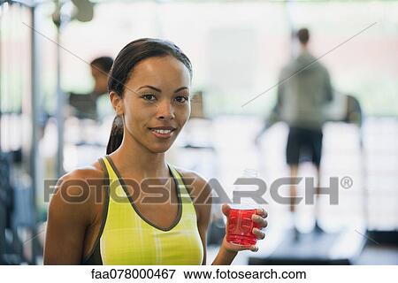 Stock Photo - Young woman holding sports drink bottle. Fotosearch