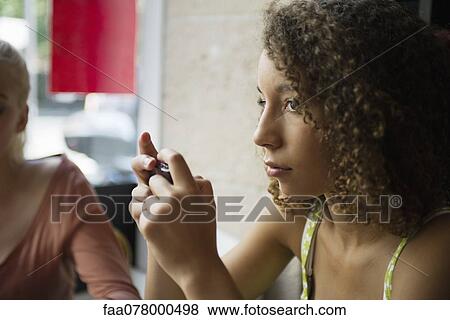 Stock Photo - Young woman looking away in thought. Fotosearch