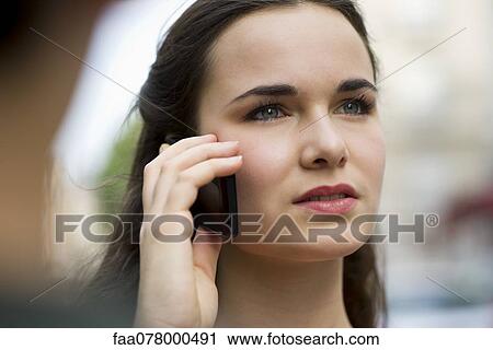 Stock Image - Young woman using cell phone. Fotosearch