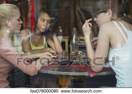 Stock Image - Young women talking together in cafe. Fotosearch