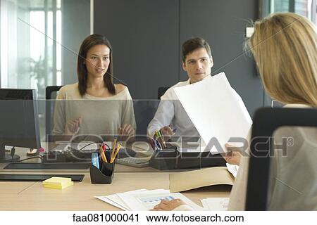 Stock Image - Associates meeting in office. Fotosearch