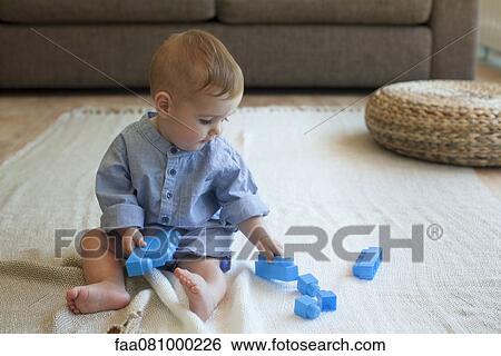 Stock Photograph - Baby boy playing with building blocks. Fotosearch