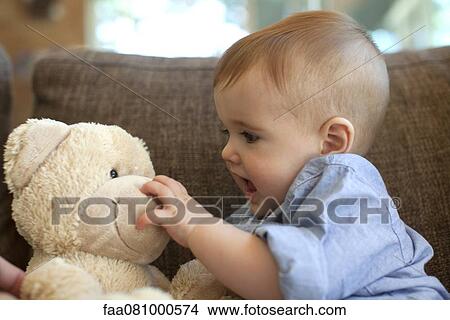 Picture - Baby boy playing with teddy bear. Fotosearch
