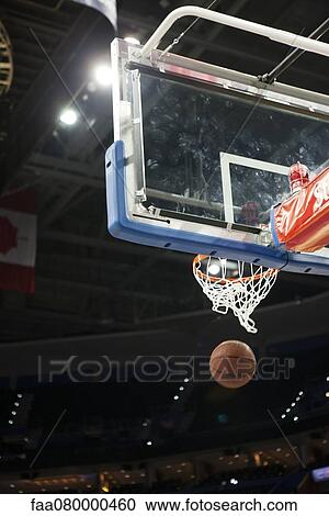 Stock Image - Basketball falling through hoop. Fotosearch