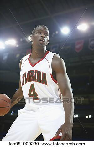 Stock Image - Basketball player dribbling basketball. Fotosearch