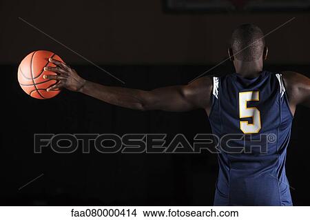Basketball player holding basketball in hand, rear view View Large Photo Image Picture - Basketball player holding basketball in hand, rear view. Fotosearch