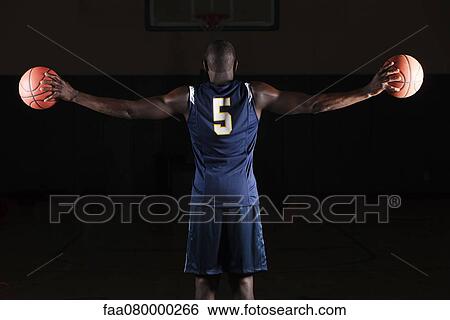 Basketball player holding basketballs in both hands, rear view View Large Photo Image Stock Photograph - Basketball player holding basketballs in both hands, rear view. Fotosearch
