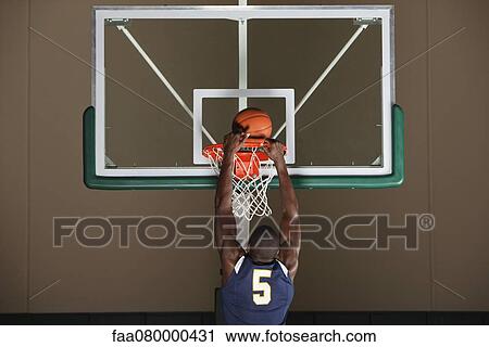 Stock Image - Basketball player making a basket. Fotosearch