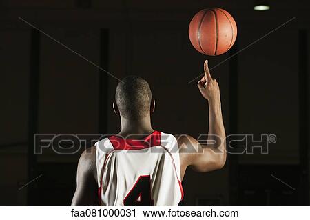 Basketball player spinning basketball atop finger, rear view View Large Photo Image Stock Image - Basketball player spinning basketball atop finger, rear view. Fotosearch